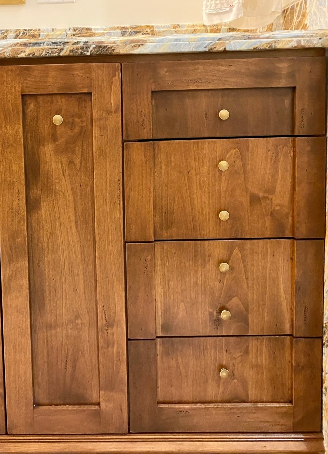 drawers with double pulls create a tailored detail in a Bel Air remodel project of Shannon Ggem Design luxury vanity in wood with marble top and brass knobs